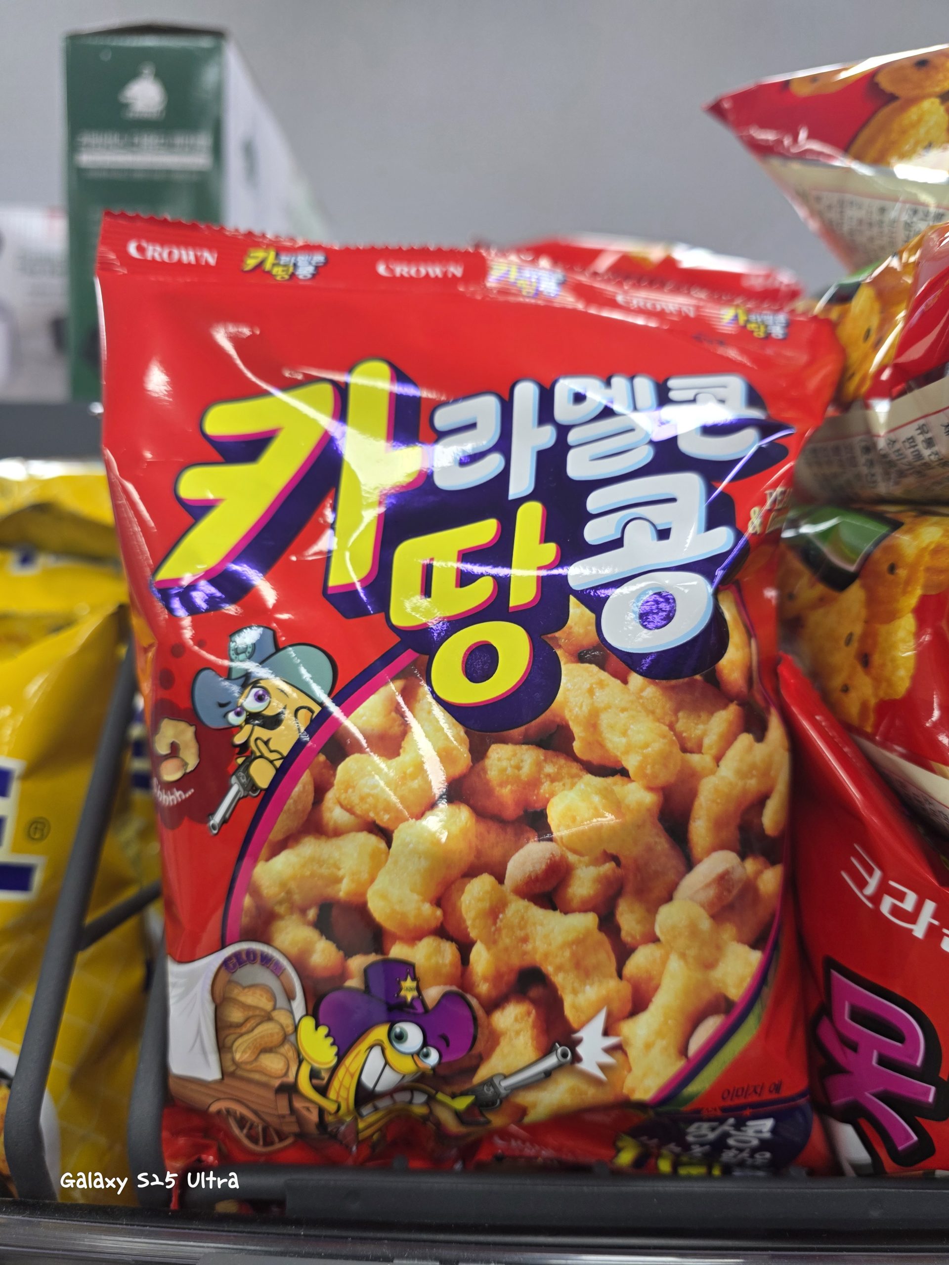 A red bag of Crown Caramel Corn and Peanuts snack displayed on a store shelf