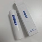 Sneaky Mood Up Moisture Lip Balm stick and its white paper packaging box with bold blue branding, displayed on a clean white desk surface.
